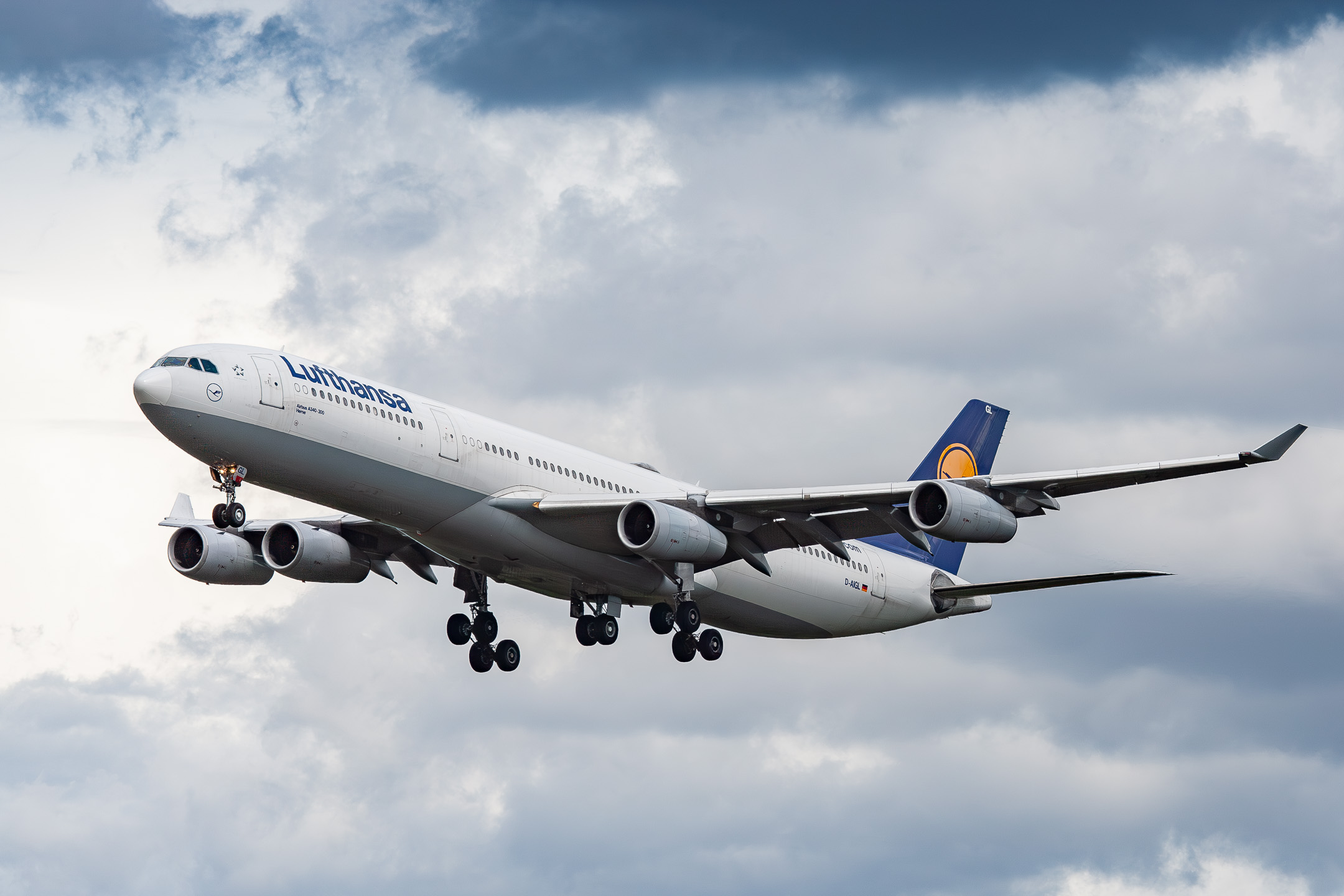 Lufthansa Airbus A340-300 ("D-AIGL") coming in on short final for runway 25 left at Frankfurt Airport on a cloudy summer afternoon, August 2021