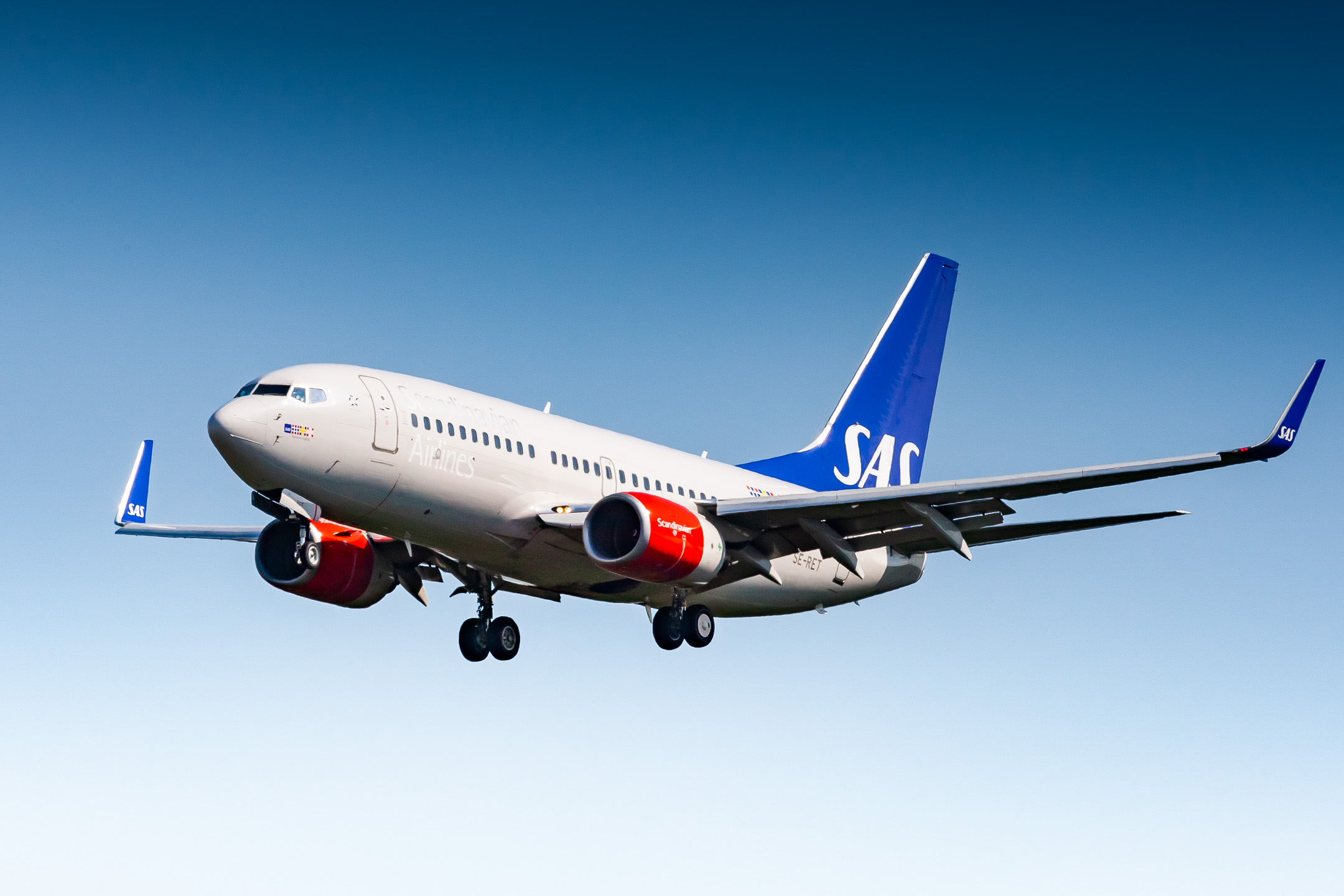 SAS Scandinavian Airlines Boeing 737-700 "SE-RET" on short final for runway 25C at Frankfurt airport on a warm summer day.