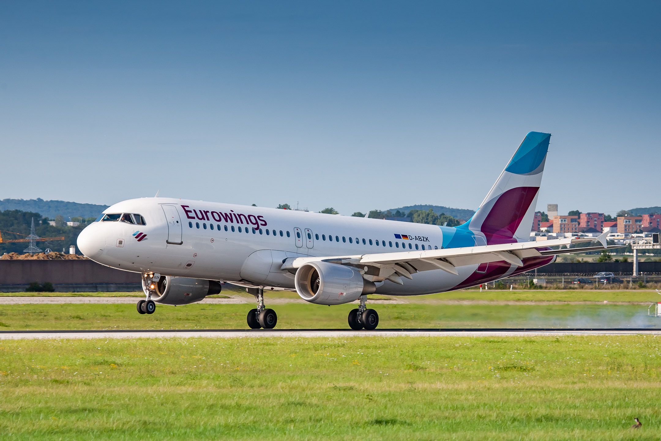 Eurowing Airbus A320-200 "D-ABZK" touching down on runway 25 at Stuttgart Airport, August 2021.