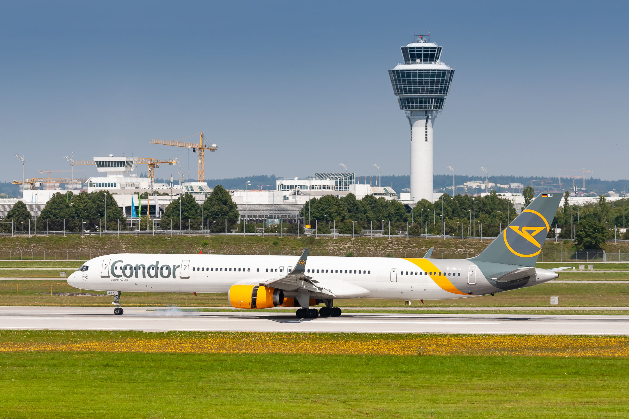 Condor Boeing 757-300 "D-ABOJ" with open reversers right after touchdown on runway 26L at München Airport on a very hot summer day, August 2021.