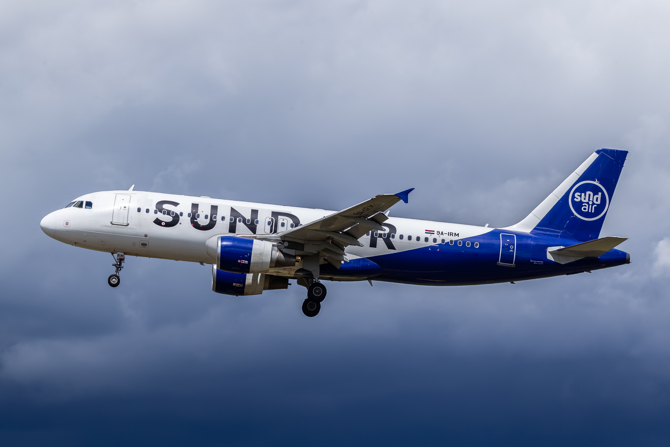 Sundair Airbus A320-200 coming in on short final for runway 23L at Düsseldorf airport just before some nasty rainshowers pass over the airport.