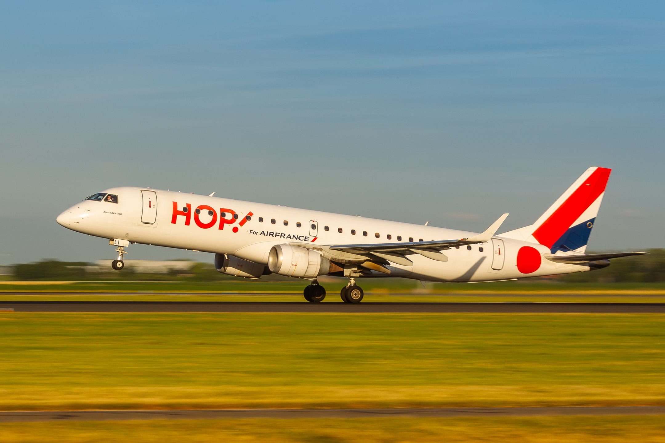 Air France Hop Embraer ERJ-190 "F-HBLI" accelerating on Polderbaan runway at Amsterdam Schiphol Airport on a hot summer evening, July 2022