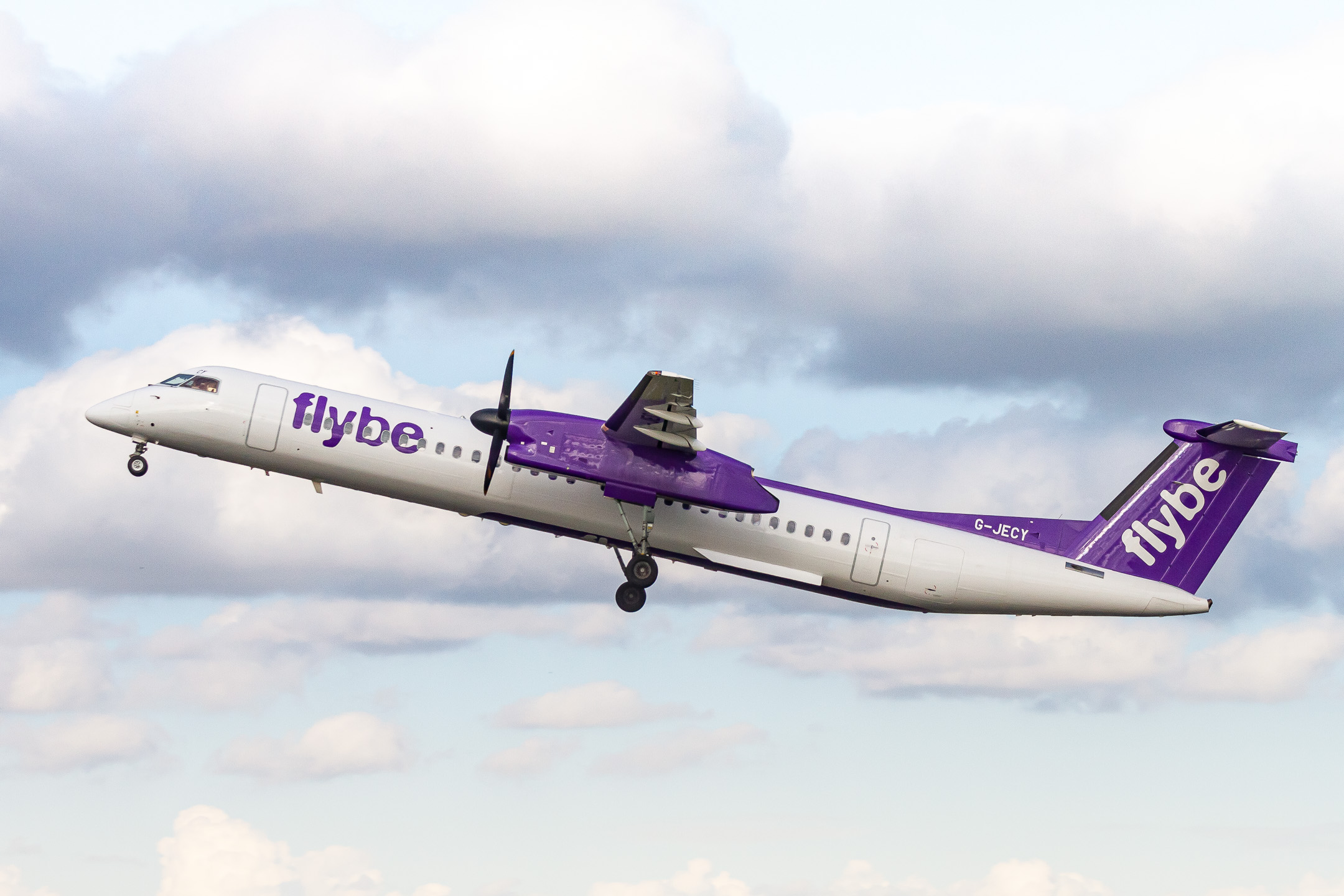 Flybe Bombardier DHC-8-400 "G-JECY" taking off from Polderbaan runway 09 left at Amsterdam Schiphol Airport on a warm summer evening, July 2022.