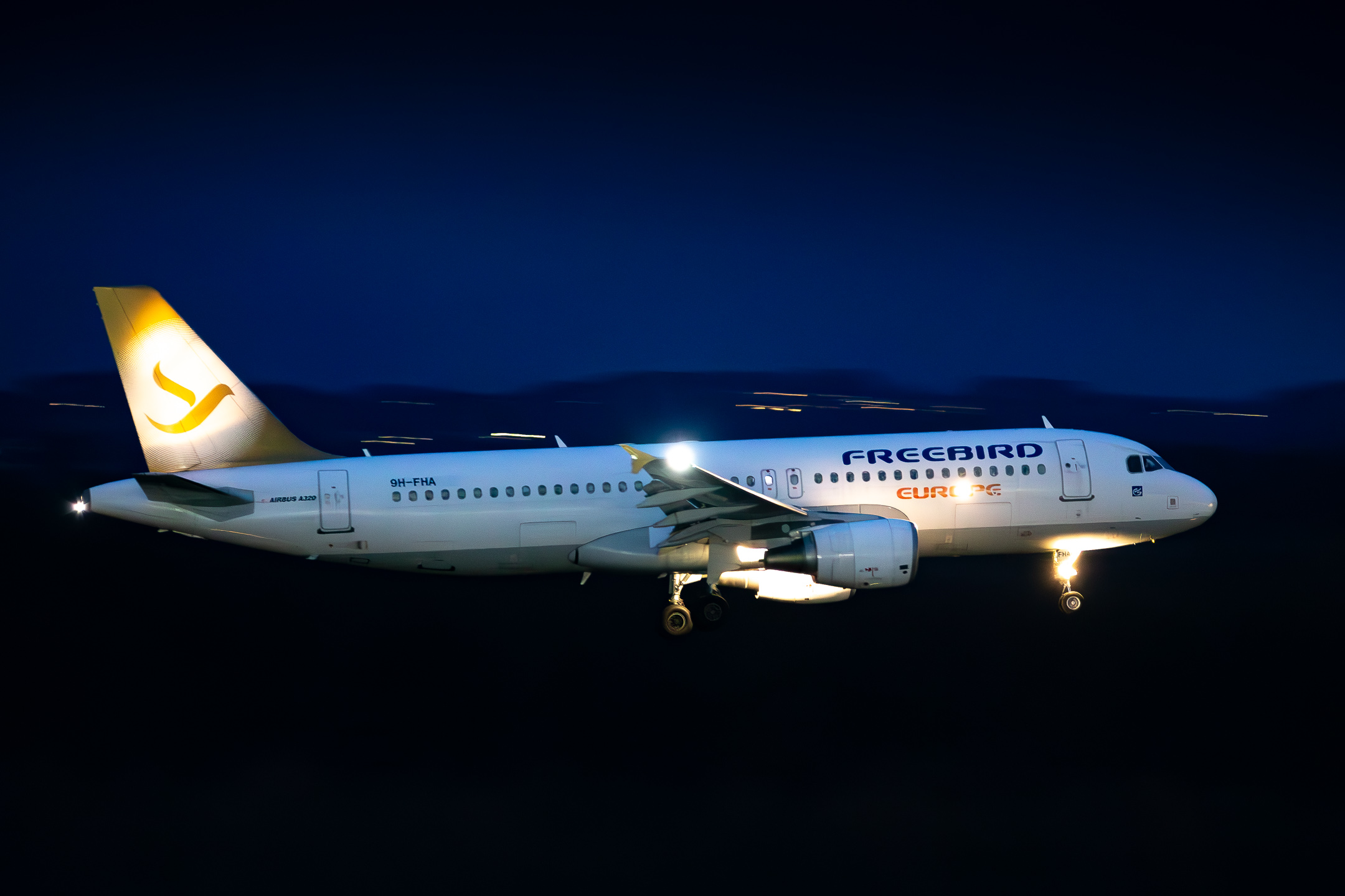 Freebird Airbus A320-200 ("9H-FHA") lit like a christmas tree shortly before touchdown on runway 14 left at Köln Bonn Airport on a winter evening, December 2022