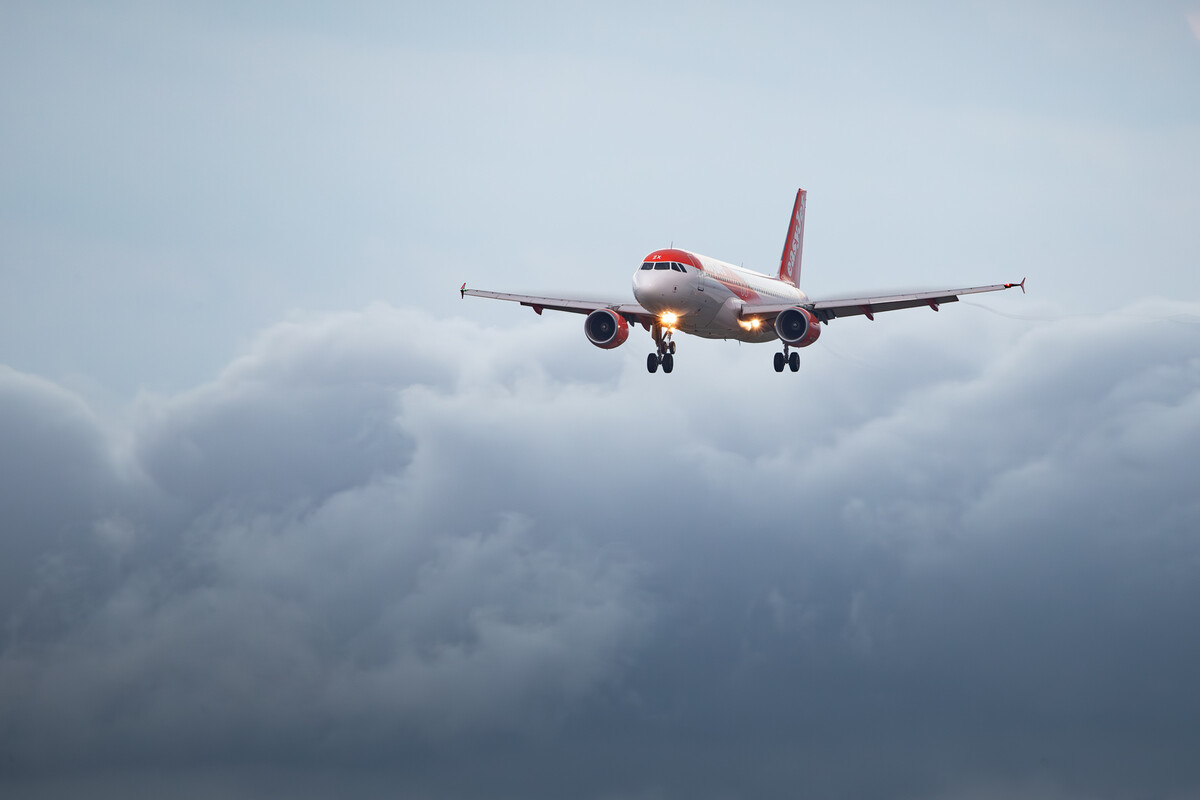 Easyjet Airbus A320-200 ("HB-JZX") on short final for runway 33 at Basel Mulhouse Airport in front of some thunderstorms on a hot summer evening, July 2023