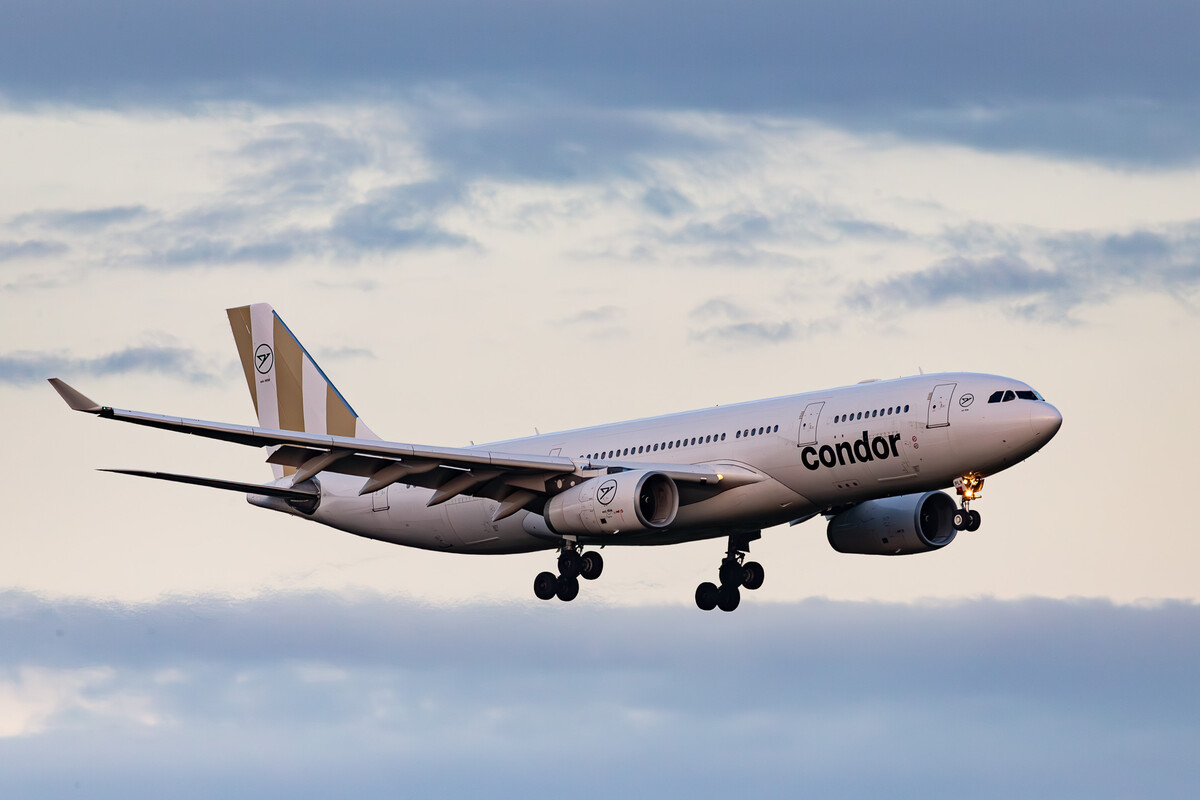 Condor Airbus A330-200 "LY-PLW" arriving in the last sunlight of the day at runway 23 left at Düsseldorf Airport on a cloudy summer evening, August 2023.