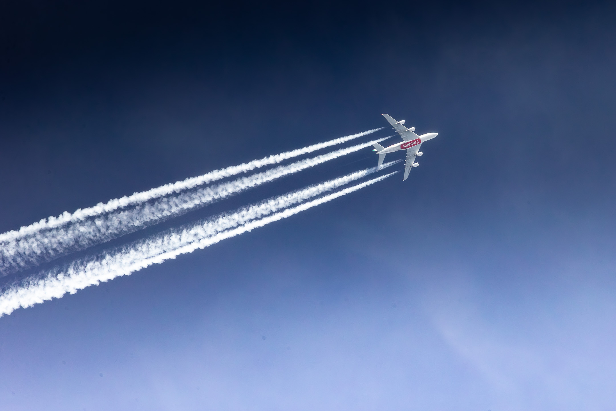 Emirates Airbus A380 passing over Liege Airport on its way to the Middle East on a bright and sunny autumn morning, October 2023